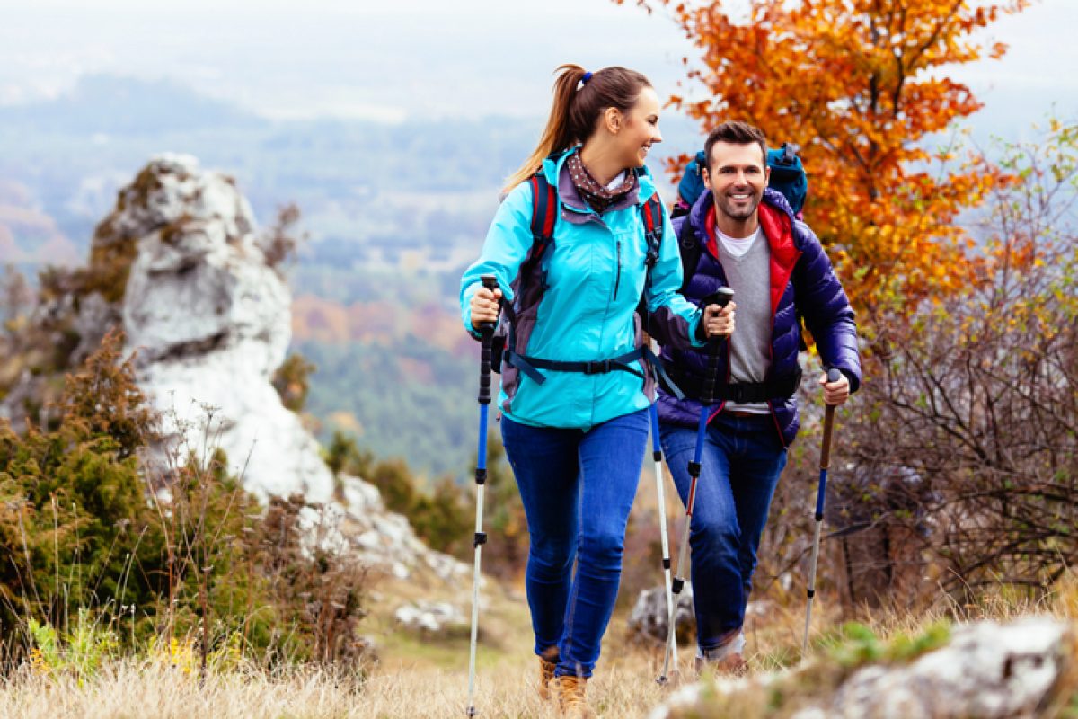 Woman and man hiking in mountains with backpacks